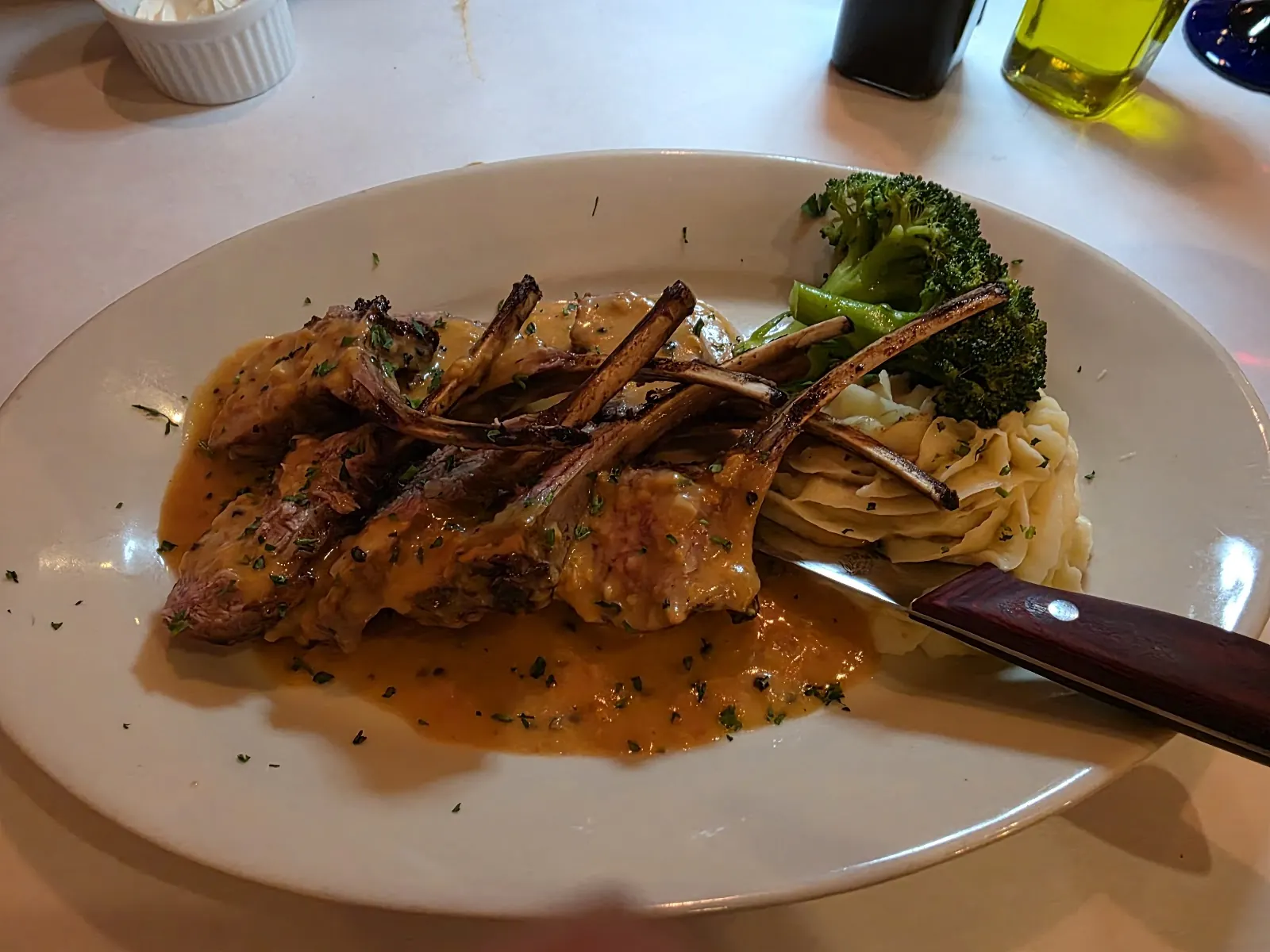 A meat entrée with sauce and broccoli rabe