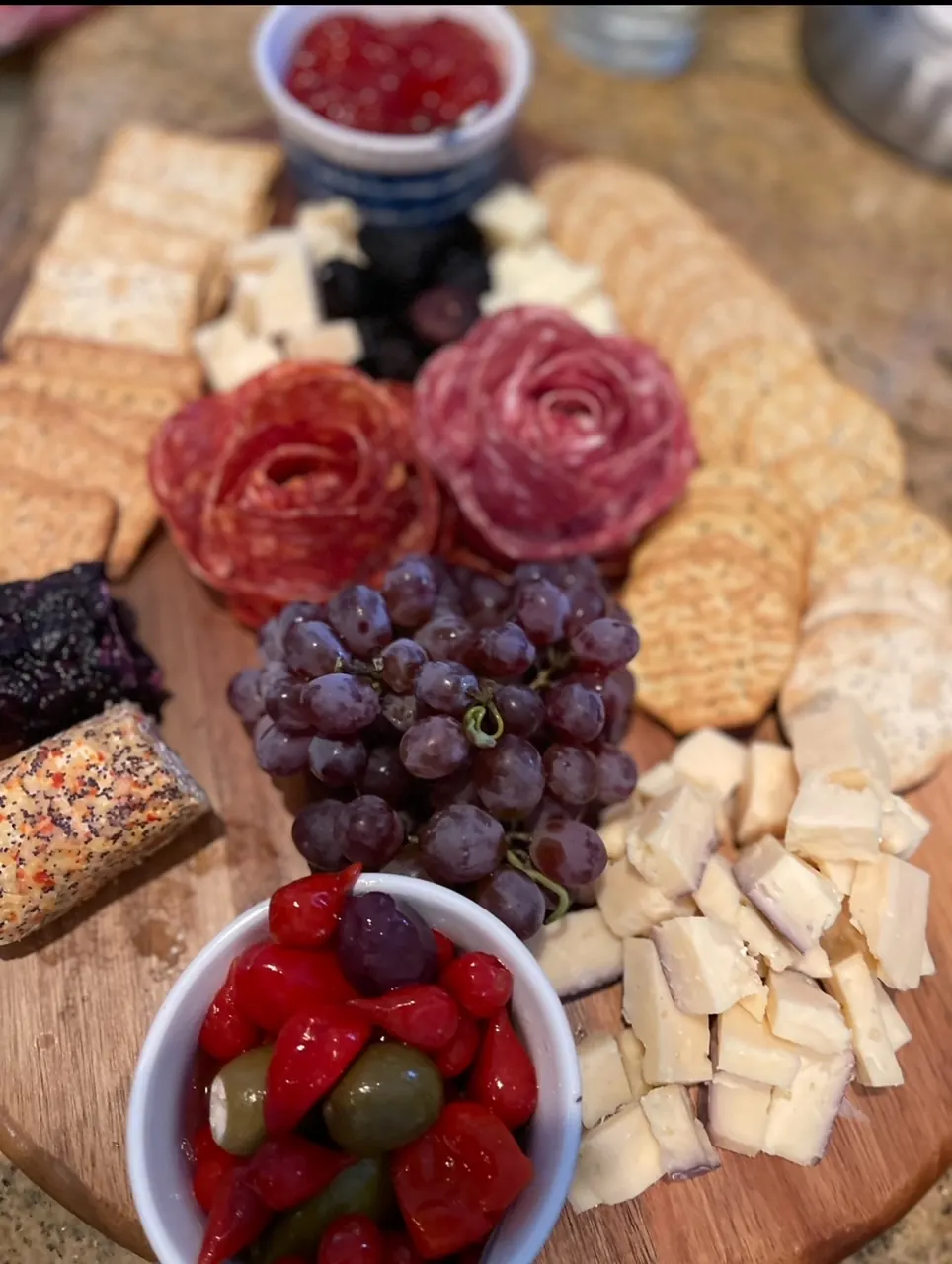 A charcuterie board with cheeses, meats, grapes and strawberries